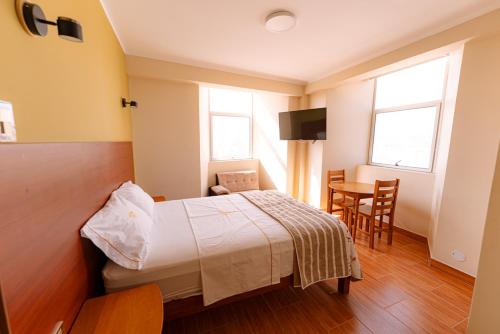 ein Schlafzimmer mit einem Bett, einem Tisch und Stühlen in der Unterkunft HsDverdi in Santa María