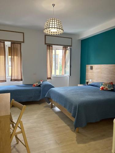 a bedroom with two beds and a chandelier at B&B Le Eolie in Milazzo