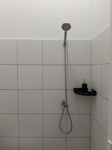 a shower with a shower head in a bathroom at Ina Guesthouse in Lovina