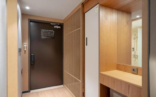 a bathroom with a black door and a mirror at Gwangju The IN Hotel in Gwangju