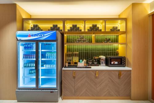 a fast food restaurant with a refrigerator in a kitchen at Vibe Hotel Managed By Nicecy in Ho Chi Minh City
