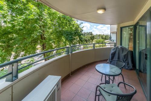 a balcony with a table and chairs on it at Central 2-bed Apartment with Gym and Spa in Canberra