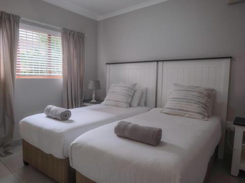 two beds in a hotel room with towels on them at Uitspan No 5 in St Lucia