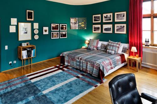 a bedroom with green walls and a bed and a chair at Gast - und Kulturhaus Der Teufelhof Basel in Basel