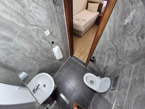 a small bathroom with a sink and a toilet at Sabah Pansiyon in Antalya
