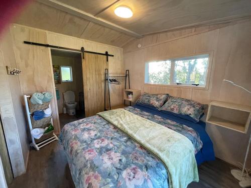 a bedroom with a bed in a small room at Hideaway Haven in Raglan