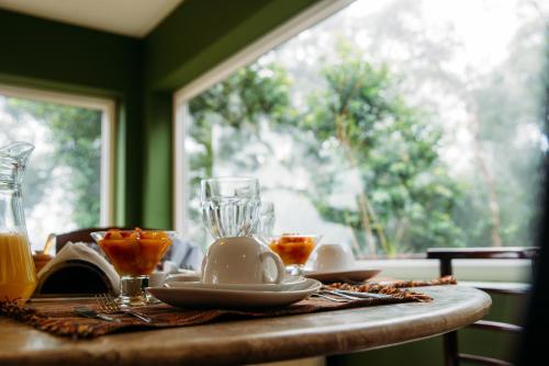 a table with a plate of food and a glass at La Réserve Suites in Monte Verde