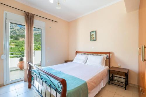a bedroom with a bed and a large window at Miraluna View in Mesochórion