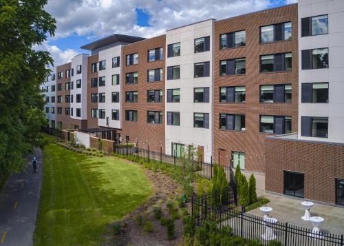 an apartment building with a green lawn in front of it at Hyatt House Columbus OSU Short North in Columbus
