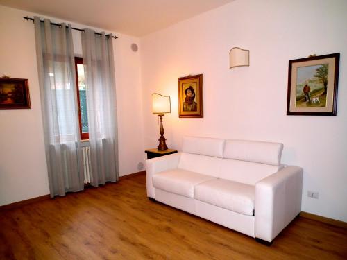 a living room with a white couch and a lamp at Suite Umberto I in Assisi