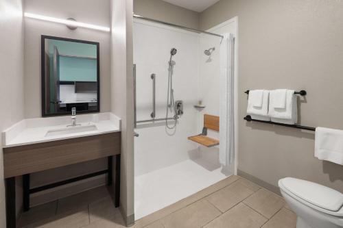 a bathroom with a shower and a sink and a toilet at ECHO Suites Extended Stay by Wyndham Houston Katy West in Katy
