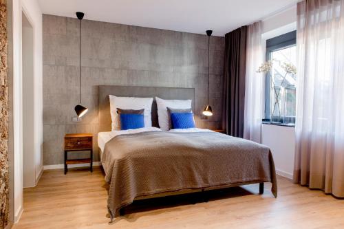 a bedroom with a large bed with blue pillows at Gasthaus Stappen in Korschenbroich
