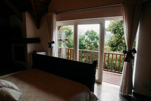 a bedroom with a bed and a large window at La Réserve Suites in Monte Verde