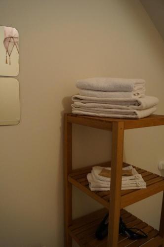 - une pile de serviettes sur une étagère dans une pièce dans l'établissement La maison d'hôtes Ty Pic, à La Vicomté-sur-Rance