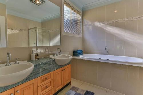 a bathroom with two sinks and a bath tub at Phillip Island Dream Getaway in Ventnor