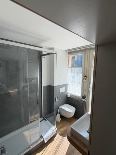 a bathroom with a glass shower and a toilet at Waldhotel Unspunnen in Interlaken