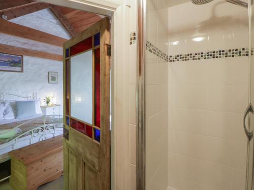 a bathroom with a shower and a glass door at Sycamore Vestry in Fishguard