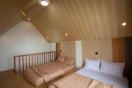 a room with two beds in a room with a roof at Lovia Villa Dieng in Kejajar