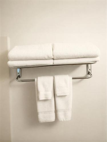 a towel rack with three white towels on it at Knights Inn Quincy in Quincy
