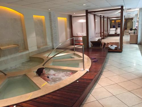 a woman in a hot tub in a hotel room at Le Parc Residential Resort in Rio de Janeiro