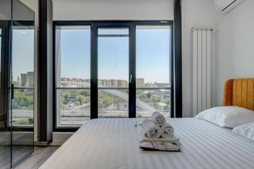 a hotel room with a bed with two towels at Studio București in Bucharest