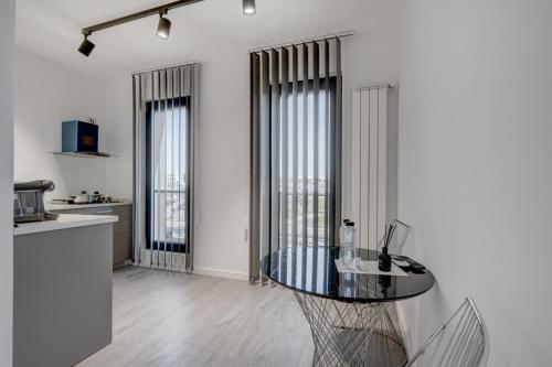a room with a table and a kitchen with windows at Studio București in Bucharest