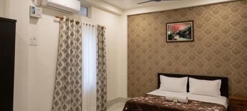 a small bedroom with a bed and a window at DZ Homestay 1BHK in Dimāpur