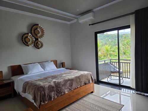 a bedroom with a large bed and a balcony at Bukit Luwih House in Munduk