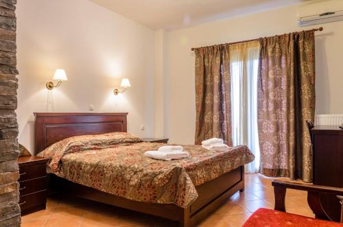 a bedroom with a bed and a window at Hotel Athina in Kato Loutraki