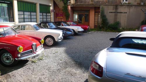 une rangée de voitures garées devant un bâtiment dans l'établissement Rose des Alpes, à Serres