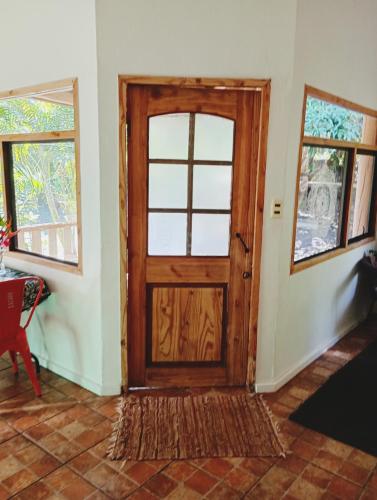 a wooden door in a room with two windows at Beautiful cabin on Easter Island in Hanga Roa