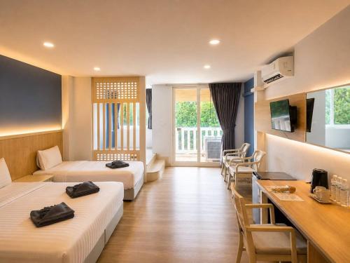 a hotel room with two beds and a table at Karon Living Room - SHA Plus in Karon Beach