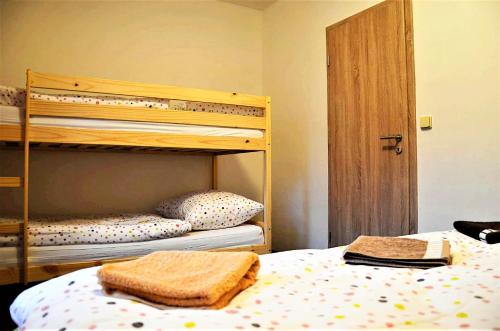 a bedroom with two bunk beds with towels on the bed at EDER- Penzion & Apartmány in Horní Planá