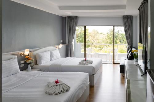 a hotel room with two beds and a balcony at The Princess Beachfront Resort in Ban Tha Fat