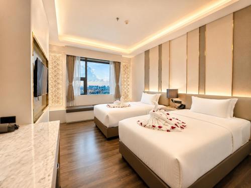 a hotel room with two beds and a television at lee hotel lat phrao in Bangkok
