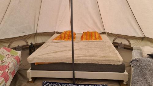 a bed in a tent with two pillows on it at Glampingtält in Österbybruk