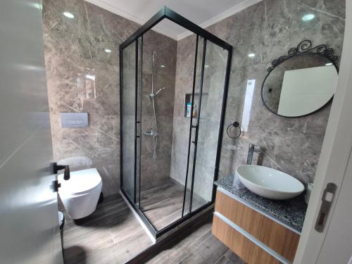 a bathroom with a shower and a toilet and a sink at Sabah Homes in Antalya