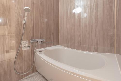 a bathroom with a bath tub and a shower at Hotel Arina HakataTaihaku in Fukuoka