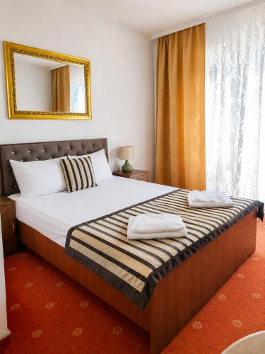 a bedroom with a bed with two towels on it at Pałacyk in Międzywodzie