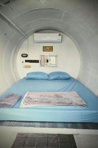 a bed in a small room with at Kua Car Camp in Lampang