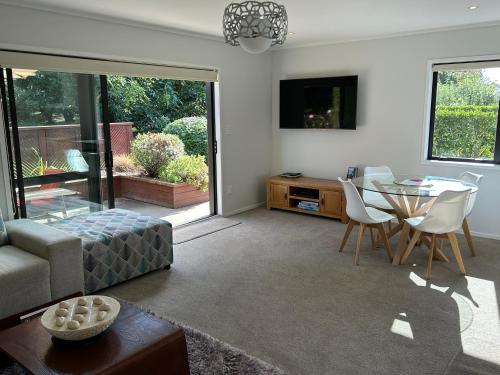 a living room with a couch and a table and a tv at Baybell Lodge in Tauranga
