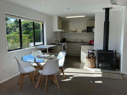 a kitchen with a table and chairs and a stove at Baybell Lodge in Tauranga