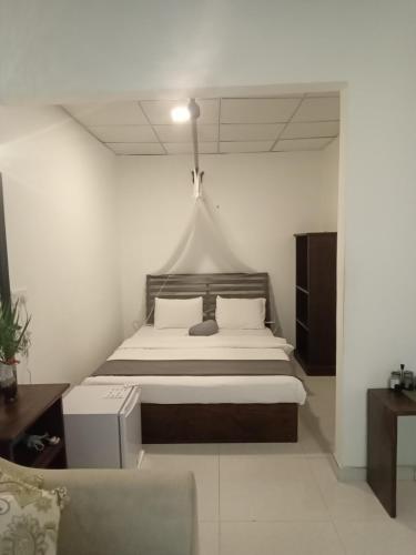 a bedroom with a bed in a white room at Hidden Lake Cottages Sigiriya in Sigiriya