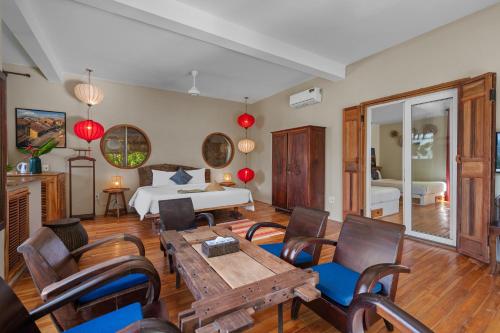 a bedroom with a bed and a table and chairs at Lea's Garden in An Bàn (2)