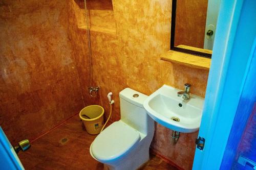 a bathroom with a toilet and a sink at Ciudad Caliente by The Lavana in Talisay