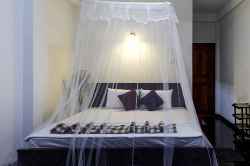 a bed with a canopy with a bunch of shoes on it at Princess of Dickoya Homestay in Hatton