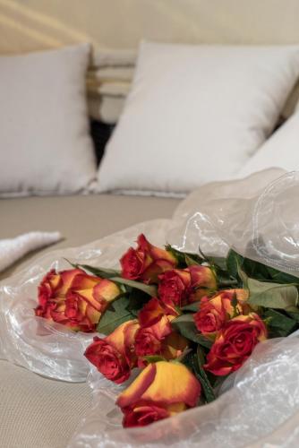 a bouquet of roses on a plate on a bed at Haus Anemone in Serfaus