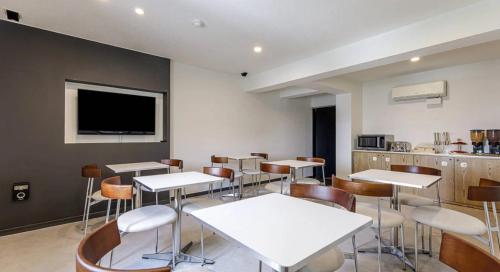 a dining room with tables and chairs and a tv at Mora Stay in Busan