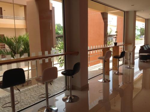 a row of bar stools in a waiting room with mirrors at Perfect Place Hotel in Surat Thani