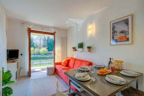 a living room with a red couch and a table at Lenni Apart. Swimming Pool and lake + WIFI - Happy Rentals in Leggiuno